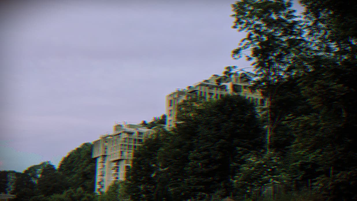 a photo of two brutalist concrete towers towering out of a forest